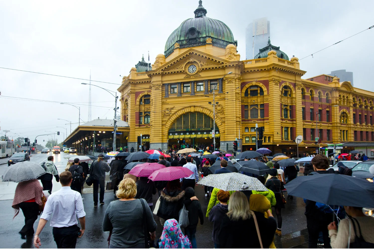 Commuters with umbrellas outside Flinders Street Station, Melbourne